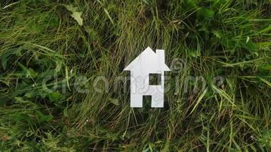 幸福家庭生活方式建设民宿理念.. 纸房子矗立在大自然的绿草中。 生命象征生态